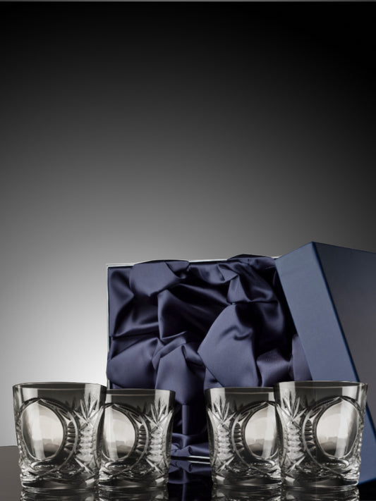 Set of four Bothwell crystal glasses with a blue satin bow in an open box on a dark background